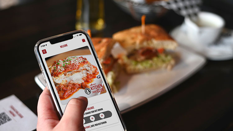 hand holding a cellphone with the Maria's app on the screen